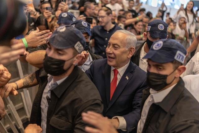 Israeli Prime Minister Benjamin Netanyahu stands amid security personnel as he meets with voters at a mall in Ramle on October 19, 2026. Israel heads to the polls on October 27 in its first election since the October 7, 2023 Hamas-led attack, in what is seen as a referendum on the prime minister. (Photo by ilia YEFIMOVICH / AFP)
