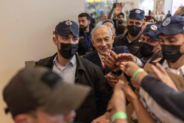 Israeli Prime Minister Benjamin Netanyahu stands amid security personnel as he meets with voters at a mall in Ramle on October 19, 2026. Israel heads to the polls on October 27 in its first election since the October 7, 2023 Hamas-led attack, in what is seen as a referendum on the prime minister. (Photo by ilia YEFIMOVICH / AFP)