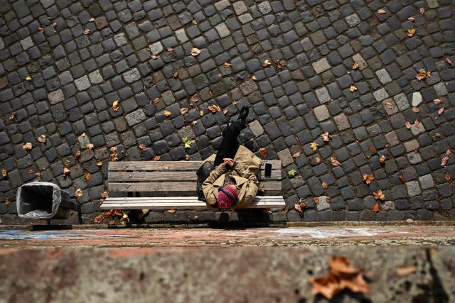 A woman rests on the Main river embankment in Frankfurt am Main, western Germany, on October 19, 2026, as air temperatures reached 16 degrees Celsius. (Photo by Kirill KUDRYAVTSEV / AFP)
