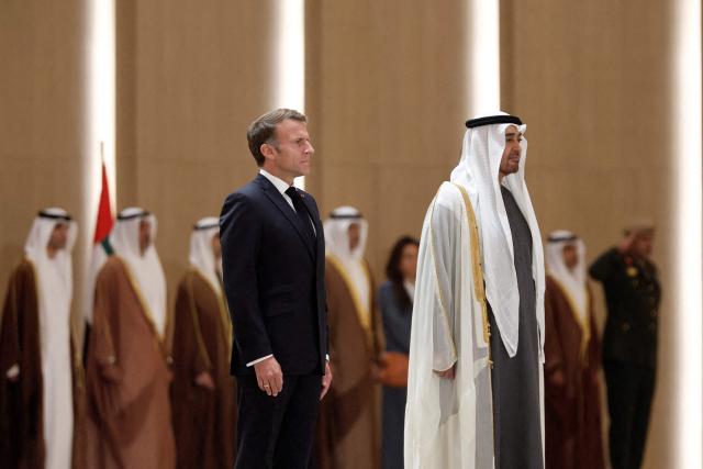 UAE President Sheikh Mohamed bin Zayed Al-Nahyan (C-R) receives France's President Emmanuel Macron (C-L) at Zayed International Airport in Abu Dhabi on October 19, 2026. (Photo by Benoit Tessier / POOL / AFP)