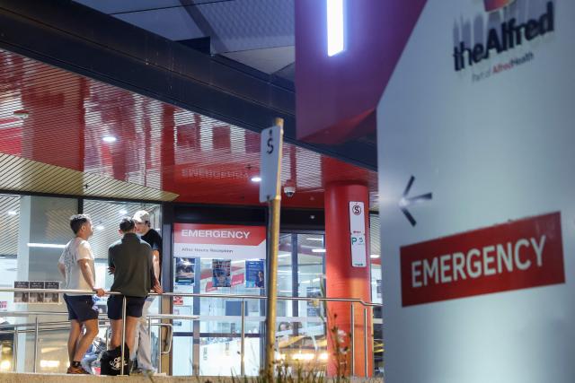 People wait outside the emergency department of The Alfred hospital, where Australian independent lawmaker Helen Haines was airlifted to for treatment with critical injuries after being struck by a car outside her office in Wangaratta, in Melbourne late on October 19, 2026. Haines was being treated in hospital for critical injuries on October 19 after being struck deliberately by a car in what officials described as a "violent" attack. (Photo by Martin KEEP / AFP)