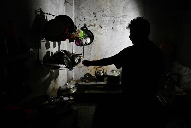 A resident uses a mobile torchlight by the kitchen stove at his house in Colombo on October 19, 2026 during a power outage as part of Sri Lanka's electricity rationing measure, two days after a nationwide blackout. Sri Lanka announced nationwide electricity rationing from October 19, two days after a complete breakdown of the national grid caused by a fault at a coal-fired generator. The state-run electricity utility said power would be cut for one hour in stages across the island during a four-hour period from October 19 evening. (Photo by Ishara S. KODIKARA / AFP)