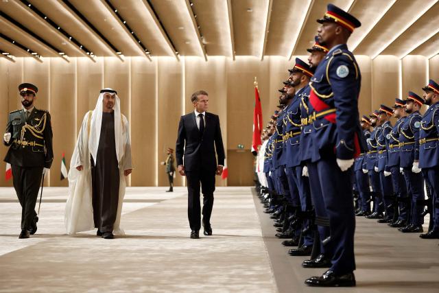UAE President Sheikh Mohamed bin Zayed Al-Nahyan (2nd-L) and France's President Emmanuel Macron (3rd-L) inspect an honour guard during a reception ceremony at Abu Dhabi International Airport in Abu Dhabi on October 19, 2026. Macron began a Gulf tour on October 19 aimed at securing oil and diesel supplies in an effort to bring down prices, after a weekend of violent protests sparked by soaring living costs. (Photo by Benoit Tessier / POOL / AFP)