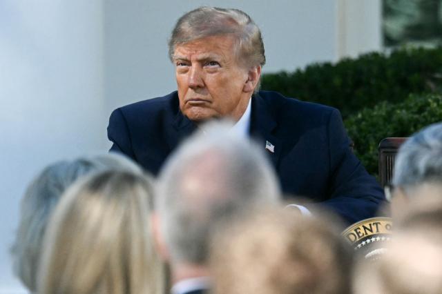 US President Donald Trump looks on as US First Lady Melania Trump (out of frame) speaks during an executive order signing ceremony in the Rose Garden of the White House in Washington, DC, on October 19, 2026. The executive order aims to a create a Women’s Health Division at the National Institutes of Health (NIH) and a White House Women’s Health Task Force. (Photo by Jim WATSON / AFP)
