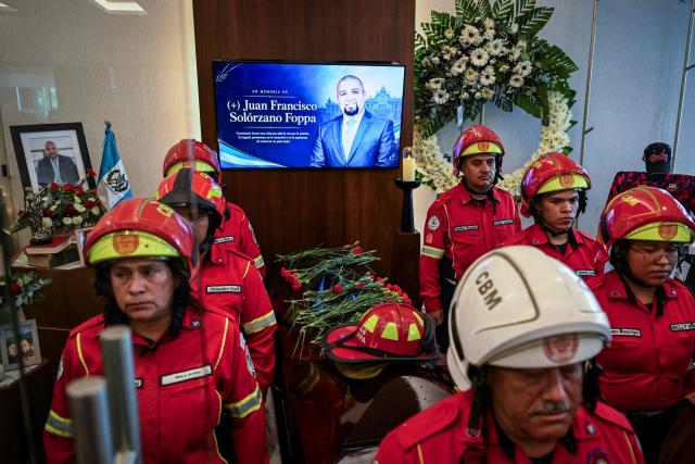 Members of the Municipal Fire Brigade stand guard around the coffin of lawyer Francisco Solorzano Foppa at a funeral home in Guatemala City on October 19, 2026. A former Guatemalan prosecutor who denounced corruption cases and alleged links between gangs and politicians was shot dead in Guatemala City on October 17, 2026, police said. Lawyer Juan Francisco Solorzano Foppa was attacked at a football field he frequented on weekends, according to a police report, which said two suspected perpetrators had been detained on a preliminary basis. (Photo by Johan ORDONEZ / AFP)