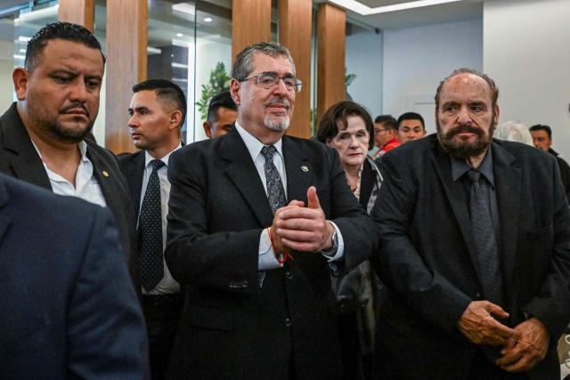 Guatemalan President Bernardo Arevalo (C) and Julio Solorzano (R), uncle of the slain lawyer, attend a memorial ceremony for Francisco Solorzano Foppa at a funeral home in Guatemala City on October 19, 2026. A former Guatemalan prosecutor who denounced corruption cases and alleged links between gangs and politicians was shot dead in Guatemala City on October 17, 2026, police said. Lawyer Juan Francisco Solorzano Foppa was attacked at a football field he frequented on weekends, according to a police report, which said two suspected perpetrators had been detained on a preliminary basis. (Photo by Johan ORDONEZ / AFP)