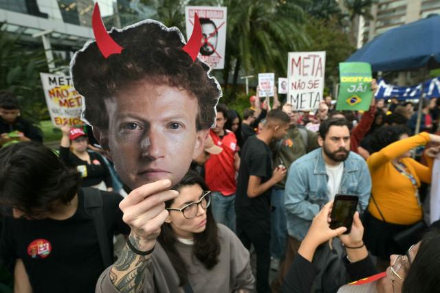 A supporter of Brazil's President and presidential candidate Luiz Inacio Lula da Silva holds a mask depicting Meta chief executive Mark Zuckerberg with red horns during a demonstration in front of Meta's headquarters in Sao Paulo, Brazil, on October 19, 2026, denouncing alleged interference by big tech companies in the Brazilian election. Brazil's electoral court on October 19, 2026 gave Meta 24 hours to show that it is taking measures to ensure equal treatment on its platforms for the campaigns of Luiz Inacio Lula da Silva and Flavio Bolsonaro, less than a week before the presidential runoff election. (Photo by NELSON ALMEIDA / AFP)