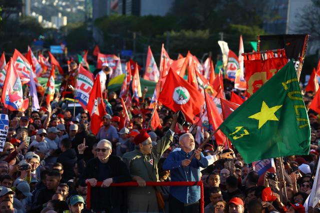 Brazil's President and presidential candidate Luiz Inacio Lula da Silva (R) of the Workers' Party (PT) waves a flag during a rally in Porto Alegre, Rio Grande do Sul state, Brazil, on October 19, 2026, ahead of the presidential runoff election. (Photo by SILVIO AVILA / AFP)