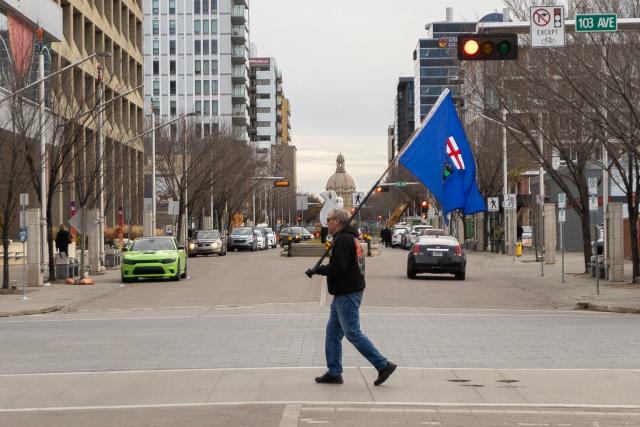 An Alberta separatist supporter carries a flag ahead of the referendum in downtown Edmonton, Alberta, on October 19, 2026. Alberta votes today to determine if it wants to pursue a binding referendum on leaving Canada, with Prime Minister Mark Carney warning a separatist win would bring dangerous uncertainty during a trade war with the United States. Polls indicate less than a quarter of people in the western Canadian province support independence. (Photo by Megan Albu / AFP)