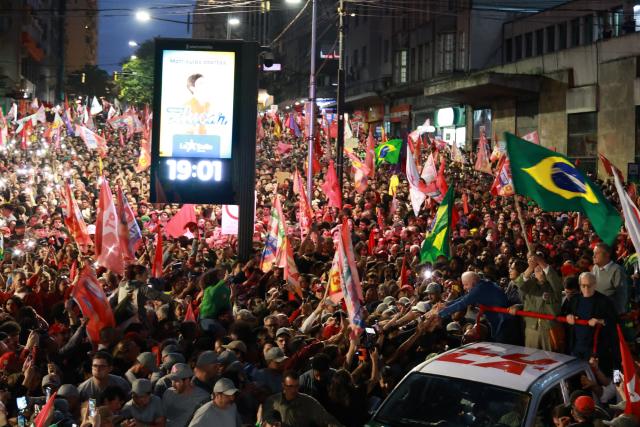 Brazil's President and presidential candidate Luiz Inacio Lula da Silva (C) of the Workers' Party (PT) greets supporters during a campaign rally in Porto Alegre, Rio Grande do Sul state, Brazil, on October 19, 2026, ahead of the presidential runoff election. (Photo by SILVIO AVILA / AFP)