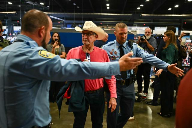A protestor is escorted out of a campaign rally with US President Donald Trump at the Heartland Credit Union Arena in Park City, Kansas, a suburb of Wichita, on October 19, 2026. (Photo by Kent NISHIMURA / AFP)