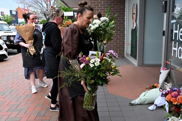 People lay flowers outside the office of Australian politician Helen Haines in the northern regional city of Wangaratta, some 250 kilometres north-east of Melbourne on October 20, 2026. Australian independent lawmaker Helen Haines underwent surgery overnight but remains in a critical condition after being struck deliberately by a car in an attack, Prime Minister Anthony Albanese said on October 20. (Photo by William WEST / AFP)
