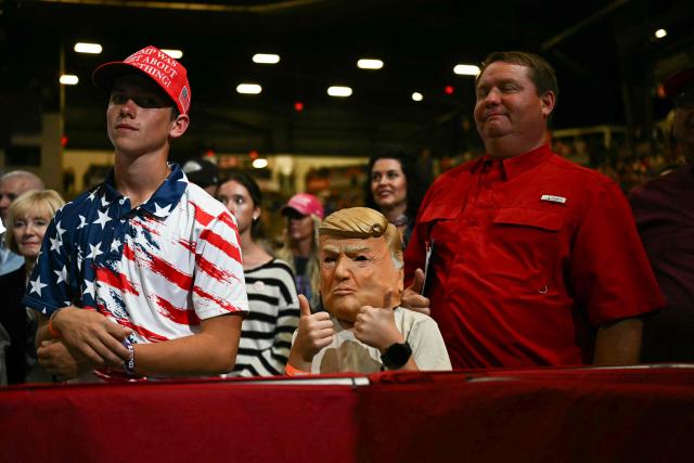 A child wearing a Donald Trump mask is seen during a campaign rally at the Heartland Credit Union Arena in Park City, Kansas, a suburb of Wichita, on October 19, 2026. (Photo by Kent NISHIMURA / AFP)