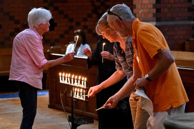 People light candles during a prayer vigil for Australian politician Helen Haines at the Holy Trinity Cathedral in the northern regional city of Wangaratta, some 250 kilometres north-east of Melbourne on October 20, 2026. Australian lawmaker Helen Haines has lost a leg after being struck by a car in a deliberate attack, local media said October 20. (Photo by William WEST / AFP)
