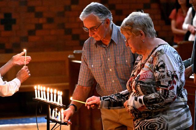 People light candles during a prayer vigil for Australian politician Helen Haines at the Holy Trinity Cathedral in the northern regional city of Wangaratta, some 250 kilometres north-east of Melbourne on October 20, 2026. Australian lawmaker Helen Haines has lost a leg after being struck by a car in a deliberate attack, local media said October 20. (Photo by William WEST / AFP)