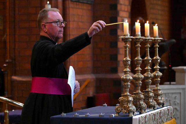 Candles are lit during a prayer vigil for Australian politician Helen Haines at the Holy Trinity Cathedral in the northern regional city of Wangaratta, some 250 kilometres north-east of Melbourne on October 20, 2026. Australian independent lawmaker Helen Haines underwent surgery overnight but remains in a critical condition after being struck deliberately by a car in an attack, Prime Minister Anthony Albanese said on October 20. Political violence is rare in Australia, but law enforcement have documented a steady rise in threats and abuse directed towards the nation's elected officials in recent years. (Photo by William WEST / AFP)