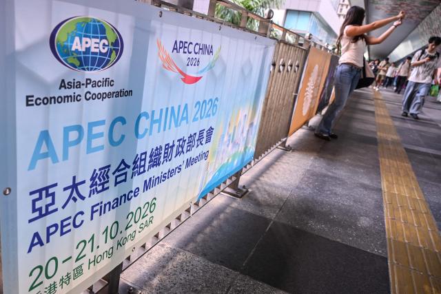 Signage for the Asia-Pacific Economic Cooperation (APEC) Finance Ministers’ Meeting is displayed on a footbridge in Hong Kong on October 20, 2026. (Photo by Peter PARKS / AFP)