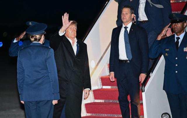 US President Donald Trump waves as he disembarks Air Force One at Joint Base Andrews, Maryland on October 19, 2026. President Trump is returning from Wichita, Kansas where he held a campaign rally ahead of the midterm elections. (Photo by Kent NISHIMURA / AFP)
