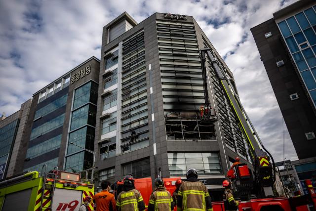 Firefighters works at the scene of a fire at a building in the Gangnam district in Seoul on October 20, 2026. (Photo by Philip FONG / AFP)