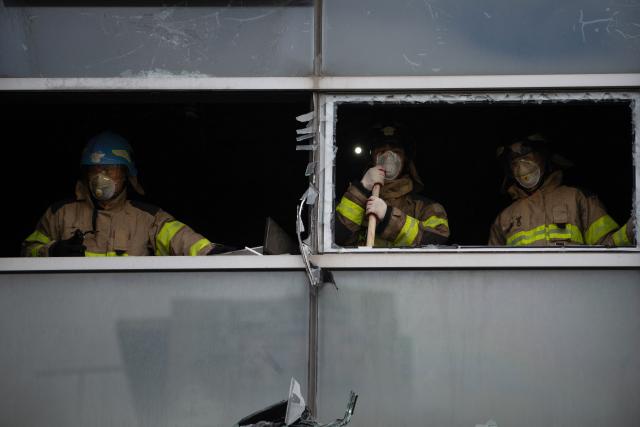 Firefighters works at the scene of a fire at a building in the Gangnam district in Seoul on October 20, 2026. (Photo by Philip FONG / AFP)