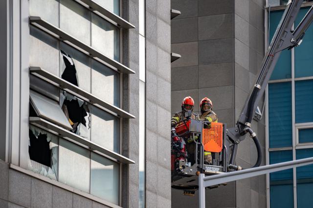 Firefighters works at the scene of a fire at a building in the Gangnam district in Seoul on October 20, 2026. (Photo by Philip FONG / AFP)