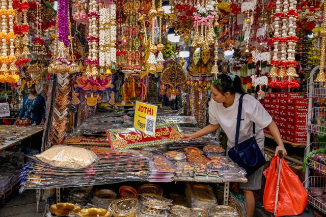 A woman looks at a shop selling decorative items for the upcoming Hindu festival of Diwali in the Little India district in Singapore on October 20, 2026. (Photo by Roslan RAHMAN / AFP)