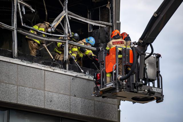 Firefighters work at the scene of a fire at a building in the Gangnam district in Seoul on October 20, 2026. (Photo by Philip FONG / AFP)