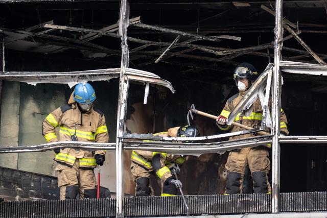 Firefighters work at the scene of a fire at a building in the Gangnam district in Seoul on October 20, 2026. (Photo by Philip FONG / AFP)