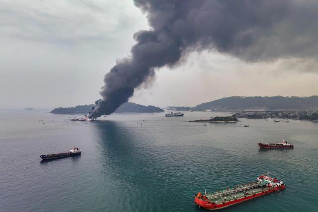 An aerial view shows smoke billowing from the KMP Batumandi ferry after it caught fire in waters off Merak in Cilegon, Banten province on October 20, 2026. (Photo by GANIS BUNGSU / AFP)