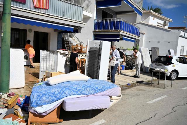 Residents clean their houses following torrential downpours in Oliva, in the Valencia region, eastern Spain on October 20, 2026. Torrential rain battered eastern Spain, unleashing severe flooding that left at least four people dead in recent days, inundated streets and forced many residents to stay indoors. (Photo by Jose JORDAN / AFP)