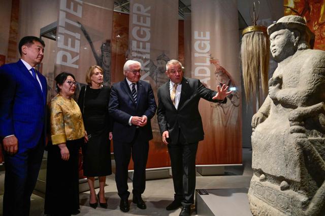 President Frank-Walter Steinmeier (2nd R), his wife Elke Buedenbender (C) and Mongolia's President Ukhnaagiin Khurelsukh (L) listen to explanations by the director of the Museum of Prehistory and Early History at the National Museums in Berlin (SPK) Matthias Wemhoff as they visit the exhibition „Dschingis Khan und die Welt der Mongolen“ (“Genghis Khan and the World of the Mongols”) at the James-Simon-Galerie museum in Berlin on October 20, 2026. Mongolia's President is on a three-day State visit in Germany. The exhibition has been organized to mark the 800th anniversary of the death of Genghis Khan, the founder of the Mongolian empire in 2027. (Photo by John MACDOUGALL / POOL / AFP)
