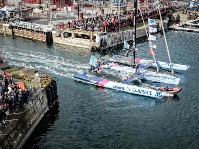 This aerial photograph shows 'Graine de Courage' French skipper Florian Gueguen abroad his multihull arriving in the harbor of Saint-Malo, a few days prior to the start of the Route du Rhum - Destination Guadeloupe solo sailing race from Saint-Malo to Pointe-a-Pitre, in Saint-Malo, western France on October 20, 2026. (Photo by Lou BENOIST / AFP)