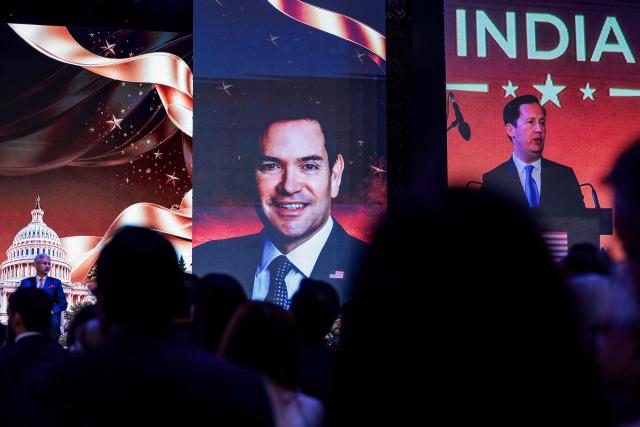 A large screen displays an image of US Secretary of State Marco Rubio (C) during a speech by US Ambassador to India Sergio Gor (R) as India's Foreign Minister Subrahmanyam Jaishankar (L) listens during the Freedom 250 reception at the Jio World Convention Centre in Mumbai on October 20, 2026. (Photo by Kylie Cooper / POOL / AFP)