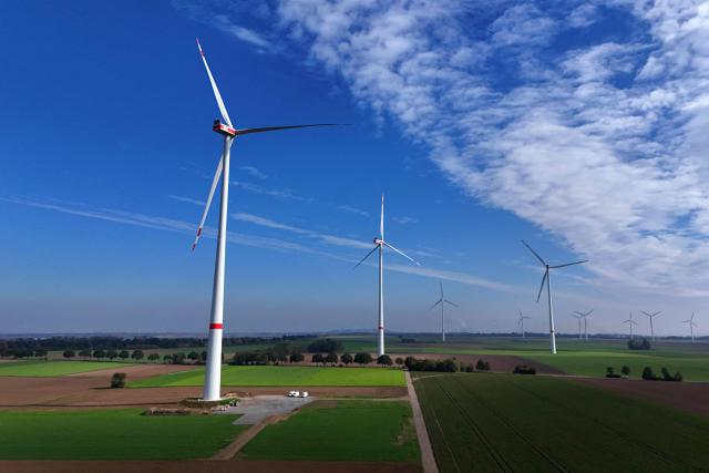 A photo shows wind turbines near the western German opencast mining region at Erkelenz-Holzweiler, western Germany on October 20, 2026. Two new wind turbines at the Erkelenz-Holzweiler wind farm, located on the edge of the Garzweiler II open-pit mine, were officially commissioned today. With a total height of approximately 250 meters each and a capacity of 7.2 megawatts each, they are the tallest wind turbines in the Heinsberg district. (Photo by Ina FASSBENDER / AFP)