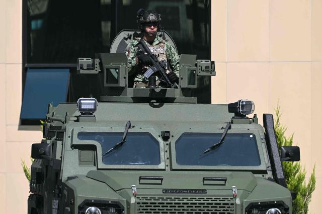A Mexican Army soldier stands guard on a military vehicle during the signing of the Interinstitutional Coordination Agreement between the Secretariat of National Defense and the Secretariat of Security and Citizen Protection in Mexico City on October 20, 2026. (Photo by Yuri CORTEZ / AFP)