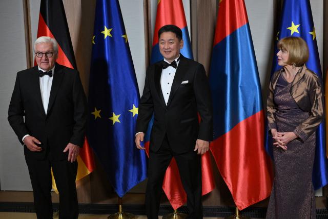 German President Frank-Walter Steinmeier (L) and his wife Elke Buedenbender (R) pose with Mongolian President Ukhnaagiin Khurelsukh as they host a banquet in his honour at the official presidential residence at the Spreebogen (Amtssitz am Spreebogen) in Berlin on October 20, 2026. Mongolia's President is on a three-day State visit in Germany. (Photo by RALF HIRSCHBERGER / AFP)