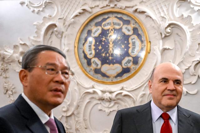 In this pool photograph distributed by the Russian state agency Sputnik, Russia's Prime Minister Mikhail Mishustin and Chinese Premier Li Qiang tour the Catherine Palace in the Tsarskoye Selo Museum-Reserve in Pushkin outside Saint Petersburg on October 20, 2026. (Photo by Alexander Miridonov / POOL / AFP)