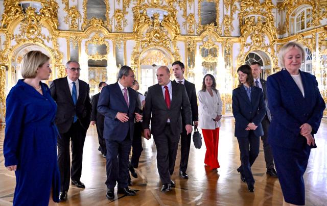 In this pool photograph distributed by the Russian state agency Sputnik, Russia's Prime Minister Mikhail Mishustin and Chinese Premier Li Qiang tour the Catherine Palace in the Tsarskoye Selo Museum-Reserve in Pushkin outside Saint Petersburg on October 20, 2026. (Photo by Alexander Miridonov / POOL / AFP)