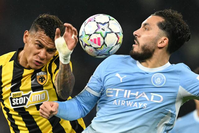 AEK's Honduran midfielder #16 Kervin Arriaga (L) vies with Manchester City's French midfielder #10 Rayan Cherki to header the ball during the UEFA Champions League football match between Manchester City and AEK Athens at the Etihad Stadium in Manchester, north west England, on October 20, 2026. (Photo by Oli SCARFF / AFP)