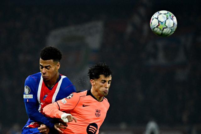 Barcelona's Portuguese defender #02 Joao Cancelo (R) head the ball past PSG's French forward #14 Desire Doue during the UEFA Champions League first round day 3 football match between Paris Saint-Germain (PSG) and FC Barcelona at the Parc de Princes stadium in Paris on October 20, 2026. (Photo by JULIEN DE ROSA / AFP)