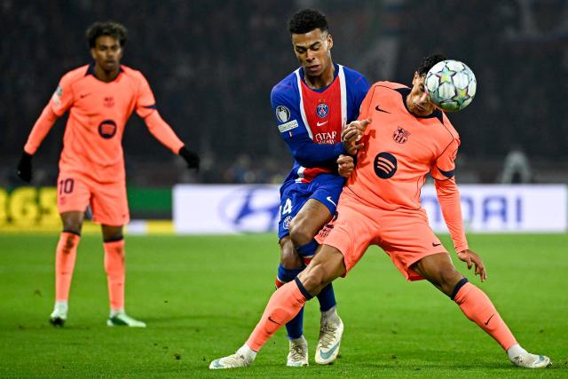 PSG's French forward #14 Desire Doue (C) fights for the ball with Barcelona's Portuguese defender #02 Joao Cancelo (R) during the UEFA Champions League first round day 3 football match between Paris Saint-Germain (PSG) and FC Barcelona at the Parc de Princes stadium in Paris on October 20, 2026. (Photo by JULIEN DE ROSA / AFP)