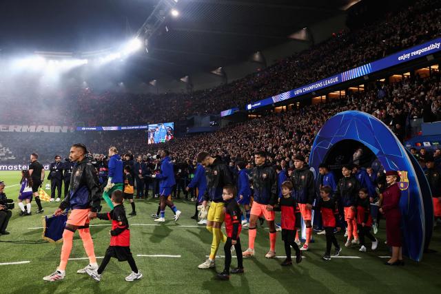Barcelona's and PSG's players enter the pitch ahead of the UEFA Champions League first round day 3 football match between Paris Saint-Germain (PSG) and FC Barcelona at the Parc de Princes stadium in Paris on October 20, 2026. (Photo by FRANCK FIFE / AFP)