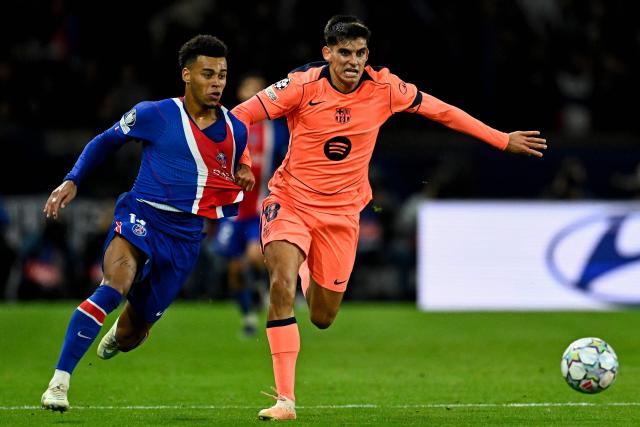 PSG's French forward #14 Desire Doue (L) and Barcelona's Spanish defender #18 Gerard Martin fight for the ball during the UEFA Champions League first round day 3 football match between Paris Saint-Germain (PSG) and FC Barcelona at the Parc de Princes stadium in Paris on October 20, 2026. (Photo by JULIEN DE ROSA / AFP)