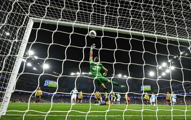 AEK's Italian goalkeeper #91 Alberto Brignoli dives as a free kick taken by Manchester City's Argentinian midfielder #17 Enzo Fernandez (unseen) hits the bar, allowing Manchester City's English midfielder #05 Elliot Anderson to score the opening goal from the rebound, during the UEFA Champions League football match between Manchester City and AEK Athens at the Etihad Stadium in Manchester, north west England, on October 20, 2026. (Photo by Oli SCARFF / AFP)