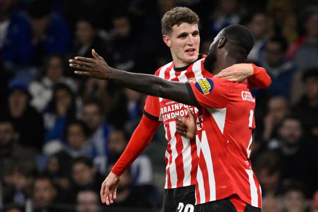 PSV Eindhoven's Dutch midfielder #20 Guus Til (L) celebrates with PSV Eindhoven's Dutch defender #02 Lutsharel Geertruida after scoring the opening goal during the UEFA Champions League first round day 3 football match between FC Porto and PSV Eindhoven at Dragao stadium in Porto, on October 20, 2026 (Photo by Miguel RIOPA / AFP)