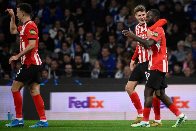 PSV Eindhoven's Dutch midfielder #20 Guus Til (C) celebrates with PSV Eindhoven's Dutch defender #02 Lutsharel Geertruida (R) after scoring the opening goal during the UEFA Champions League first round day 3 football match between FC Porto and PSV Eindhoven at Dragao stadium in Porto, on October 20, 2026 (Photo by Miguel RIOPA / AFP)