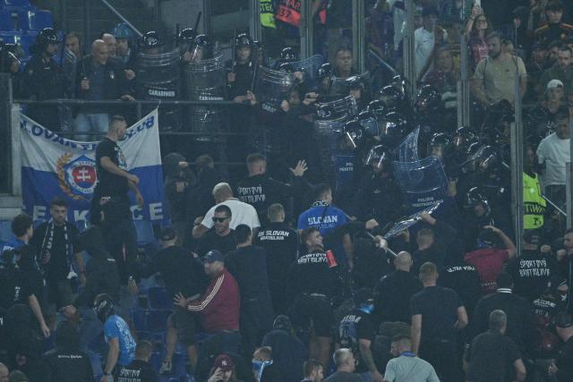Slovan Bratislava's supporters clash with riot police in the stands during the UEFA Champions League - 1st round day 3 football match between AS Roma and Slovan Bratislava at the Olympic Stadium in Rome on October 20, 2026. (Photo by Andreas SOLARO / AFP)