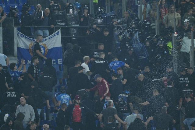 Slovan Bratislava's supporters clash with riot police in the stands during the UEFA Champions League - 1st round day 3 football match between AS Roma and Slovan Bratislava at the Olympic Stadium in Rome on October 20, 2026. (Photo by Andreas SOLARO / AFP)