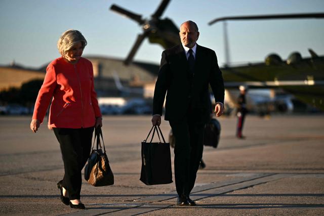 White House Chief of Staff Susie Wiles (L) and US Secretary of Commerce Howard Lutnick walk to baord Air Force One at Joint Base Andrews in Maryland, as they travel with US President Donald Trump, on October 20, 2026. President Trump is travelling to North Carolina to support Republican candidates. (Photo by Kent NISHIMURA / AFP)