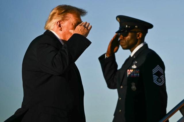 US President Donald Trump returns a salute as he boards Air Force One at Joint Base Andrews in Maryland, on October 20, 2026. President Trump is travelling to North Carolina to support Republican candidates. (Photo by Kent NISHIMURA / AFP)